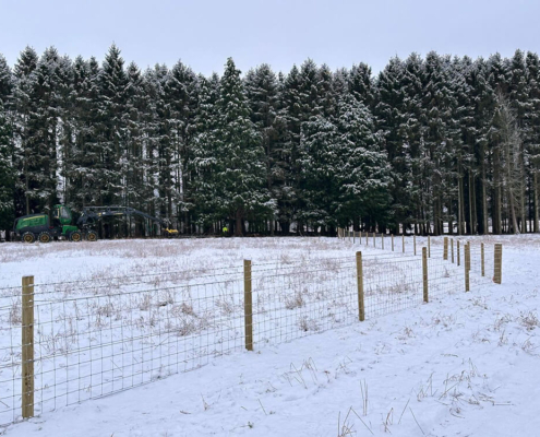 Post and rail fencing with stock fencing installed in snowy countryside near Tomatin