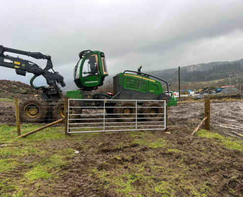 Metal field gate and fencing works beside forestry machinery near Tomatin