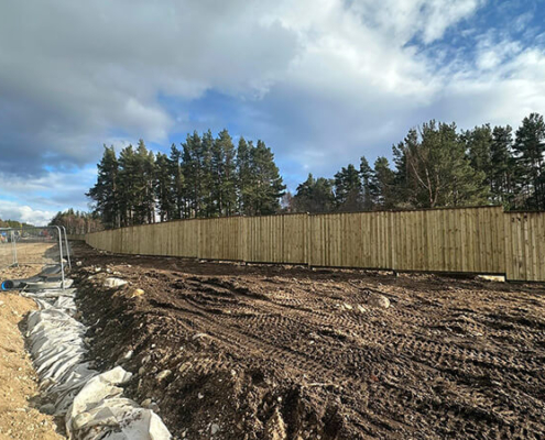Timber post and wire fencing installed through snow-covered rural ground