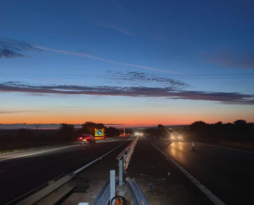 Dusk view of trunk road barrier upgrade works with new safety barrier installation