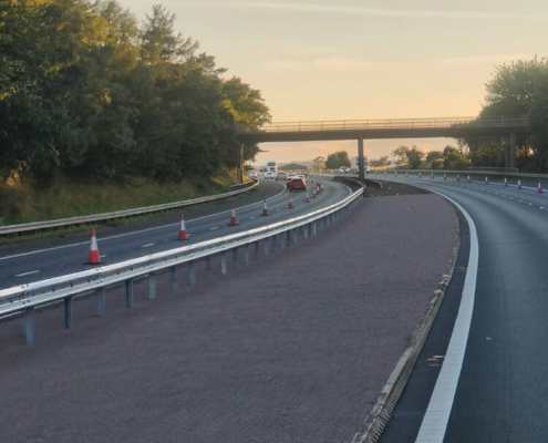 New central reserve safety barrier on trunk road approaching bridge structure